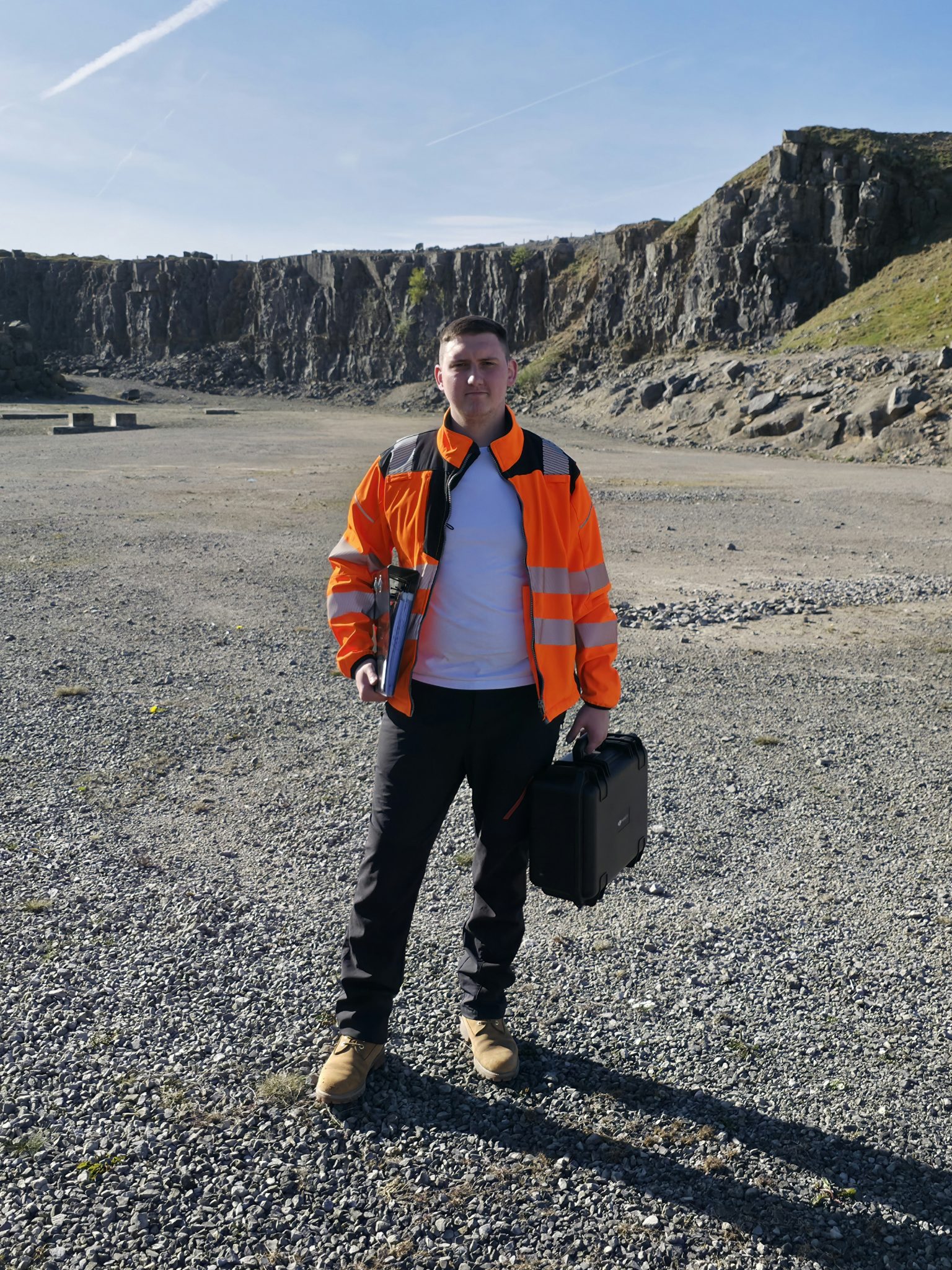 Commercial drone operator on an industrial site preparing equipment for aerial inspection work